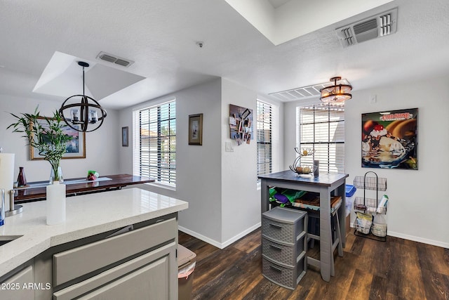 dining area with dark wood-style flooring, visible vents, and a notable chandelier