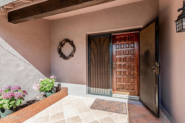 view of exterior entry featuring stucco siding