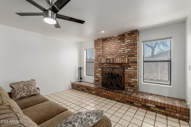 living room featuring a brick fireplace, light tile patterned flooring, and ceiling fan