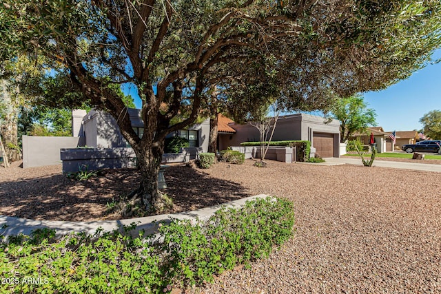 view of front facade featuring stucco siding, driveway, and a garage