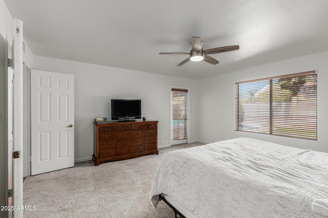 carpeted bedroom featuring baseboards and a ceiling fan
