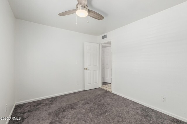 carpeted spare room with ceiling fan, visible vents, and baseboards