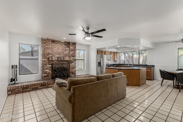 living room featuring ceiling fan, a fireplace, recessed lighting, and light tile patterned flooring