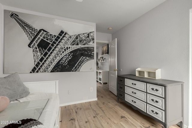 bedroom with light wood-style flooring and baseboards
