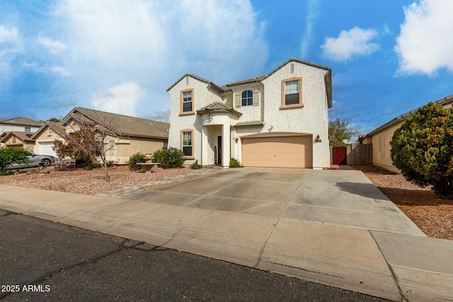 view of front of house featuring fence, a tiled roof, stucco siding, driveway, and an attached garage