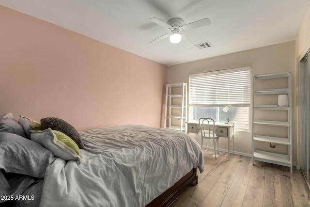 bedroom with light wood finished floors, visible vents, a ceiling fan, and baseboards