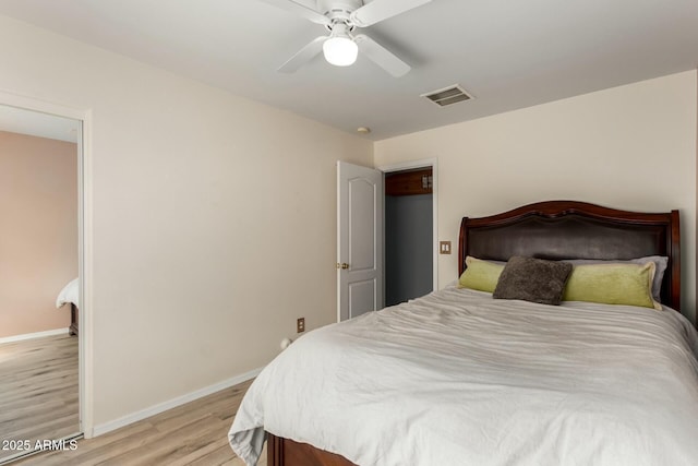 bedroom featuring ceiling fan, light wood-style floors, visible vents, and baseboards