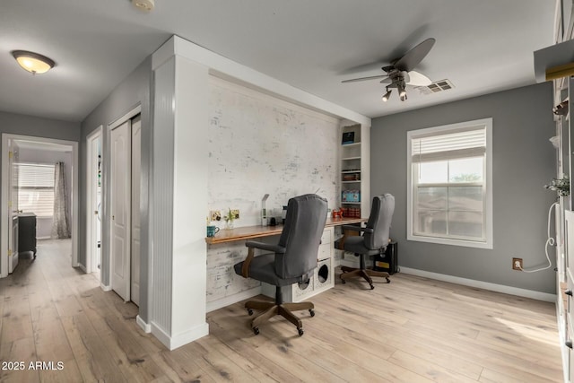 office with a wealth of natural light, visible vents, hardwood / wood-style floors, and a ceiling fan