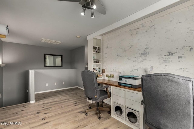 office area with a ceiling fan, wood finished floors, and baseboards