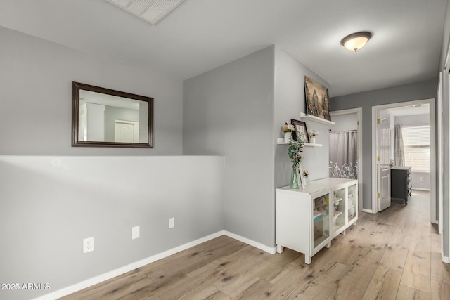 hall with wood finished floors and baseboards