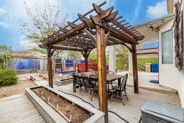 deck featuring a pergola, outdoor dining area, and a fenced backyard