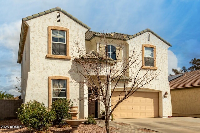 mediterranean / spanish home featuring an attached garage, driveway, and stucco siding
