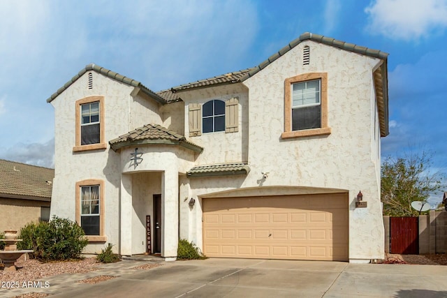mediterranean / spanish-style house featuring stucco siding, concrete driveway, and an attached garage