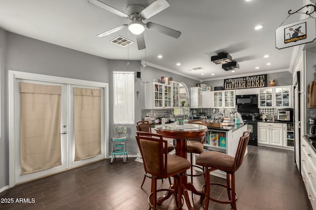 dining area with visible vents, crown molding, a ceiling fan, and dark wood-style flooring
