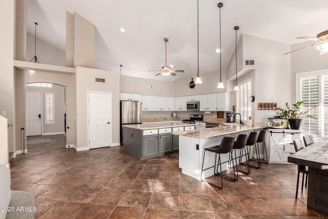 7029 E Monte Cir, Mesa, AZ 85209 - kitchen with a ceiling fan, appliances with stainless steel finishes, high vaulted ceiling, a sink, and baseboards