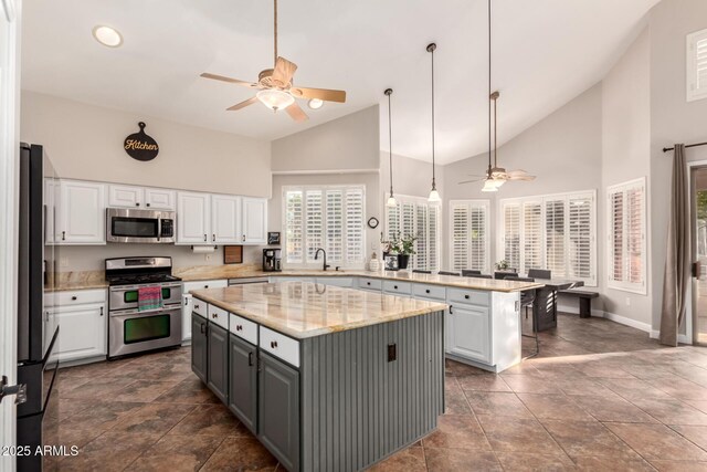 7029 E Monte Cir, Mesa, AZ 85209 - kitchen with appliances with stainless steel finishes, a ceiling fan, white cabinetry, and high vaulted ceiling