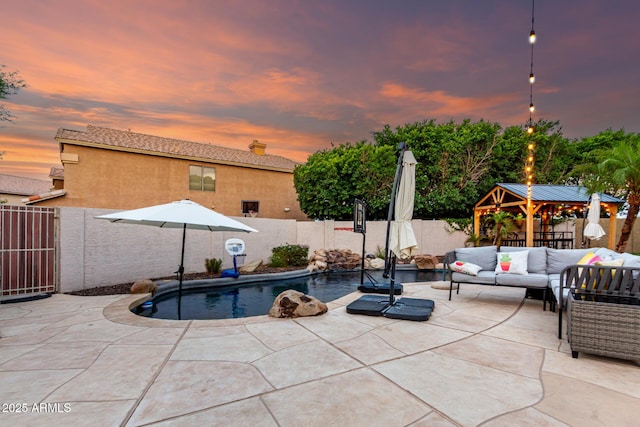 7029 E Monte Cir, Mesa, AZ 85209 - pool at dusk with a gazebo, outdoor lounge area, a fenced backyard, and a patio area