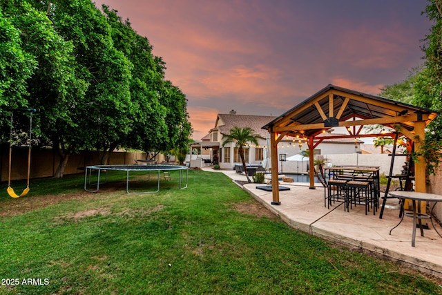 7029 E Monte Cir, Mesa, AZ 85209 - yard at dusk featuring a gazebo, a trampoline, and a patio area