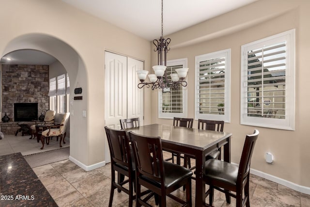 20532 W Summit Pl, Buckeye, AZ 85396 - dining space with baseboards, a chandelier, and a stone fireplace