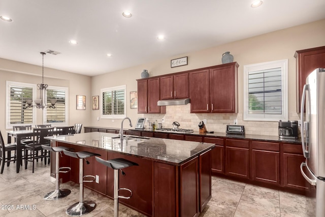 20532 W Summit Pl, Buckeye, AZ 85396 - kitchen with a sink, stainless steel appliances, under cabinet range hood, recessed lighting, and an island with sink