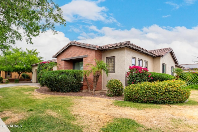 20532 W Summit Pl, Buckeye, AZ 85396 - view of front of home with a tiled roof, stucco siding, a front yard, and brick siding