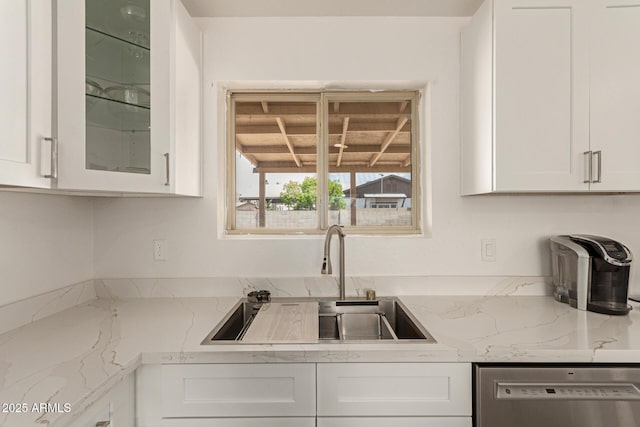 2826 E Cactus Rd, Phoenix, AZ 85032 - kitchen with stainless steel dishwasher, white cabinetry, glass insert cabinets, and light stone countertops