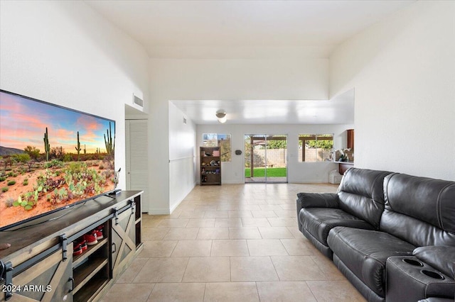 living room featuring light tile patterned flooring and a high ceiling