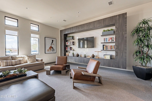 living area featuring baseboards, visible vents, and carpet flooring