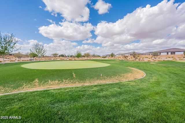 view of community featuring view of golf course and a yard