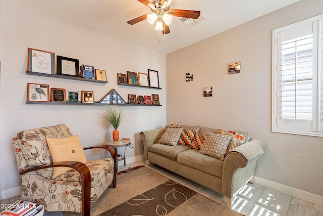 living room featuring baseboards, visible vents, and a ceiling fan