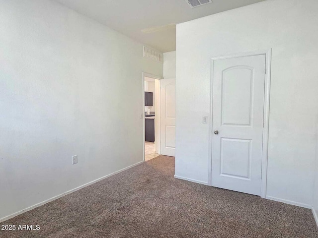 unfurnished bedroom with carpet, visible vents, and baseboards