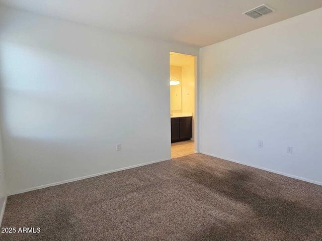 empty room featuring light carpet, visible vents, and baseboards