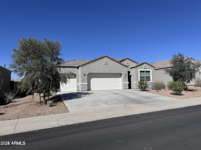 mediterranean / spanish house featuring concrete driveway, an attached garage, a tile roof, and stucco siding