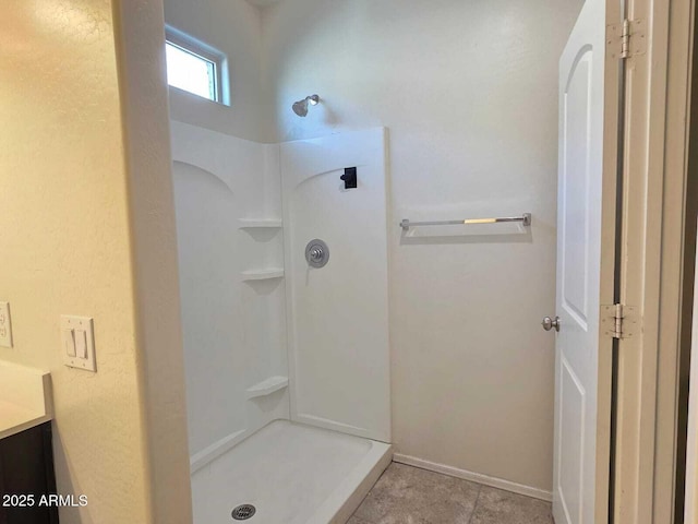 full bathroom featuring baseboards, walk in shower, and vanity