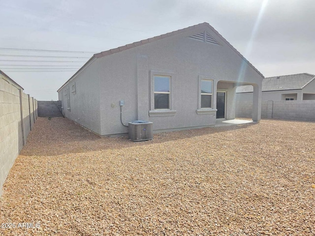 back of property featuring cooling unit, a fenced backyard, and stucco siding