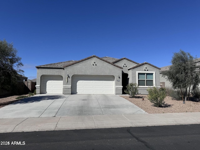 mediterranean / spanish-style home featuring a garage, driveway, and stucco siding