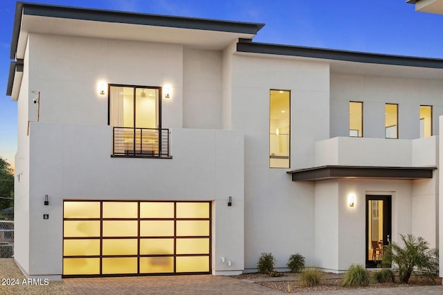 contemporary house featuring a garage and a balcony