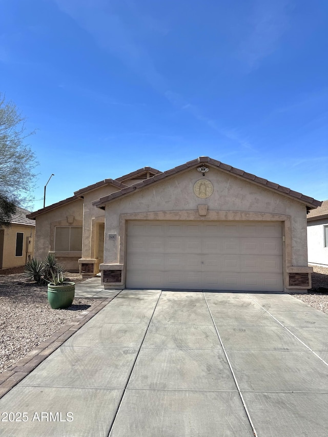 ranch-style home featuring concrete driveway, an attached garage, and stucco siding