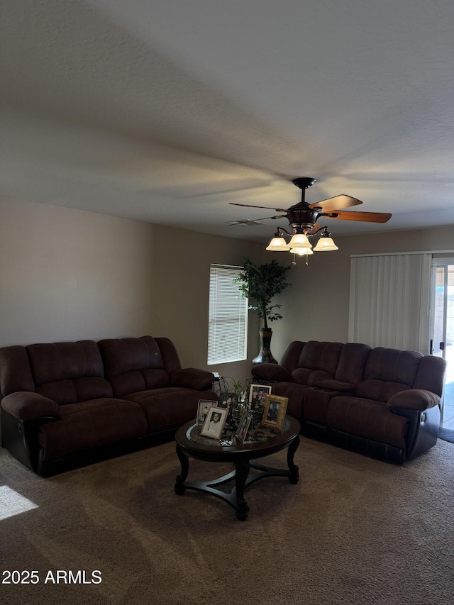 living area with a ceiling fan and carpet flooring