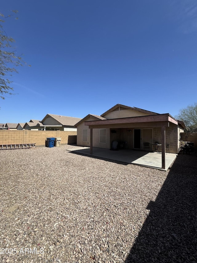 rear view of property featuring a patio area and fence