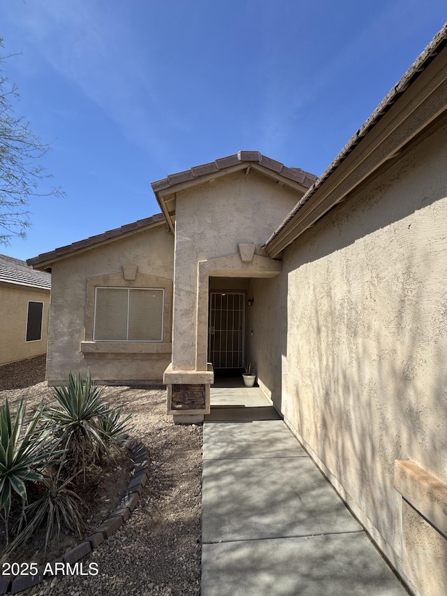 property entrance with stucco siding