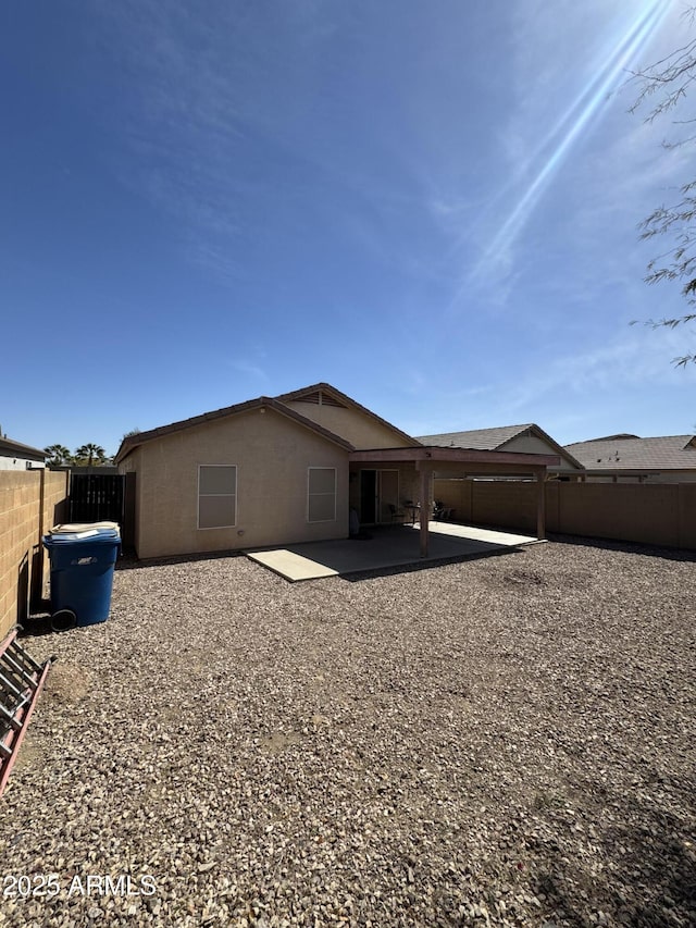 rear view of house with a patio, a fenced backyard, and stucco siding