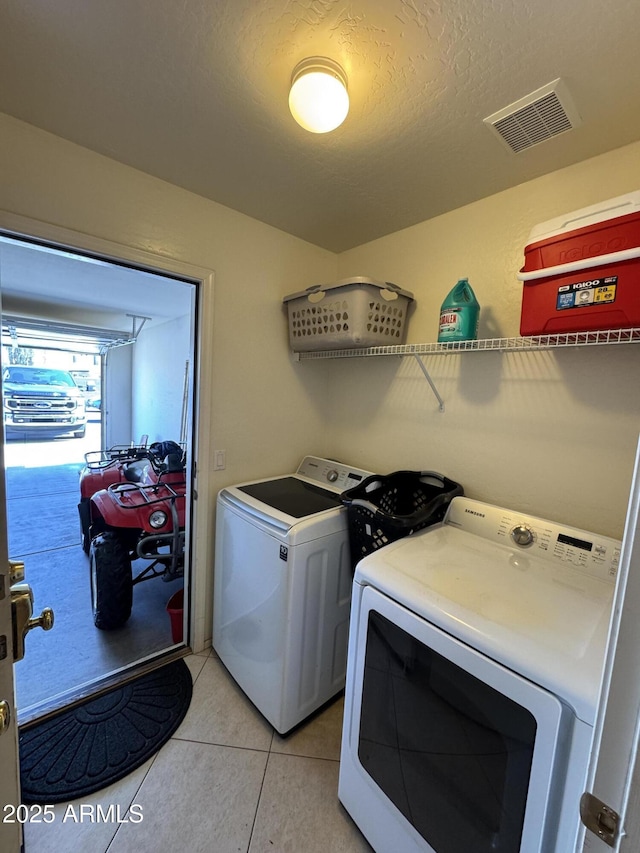 washroom with light tile patterned floors, visible vents, a textured ceiling, laundry area, and independent washer and dryer