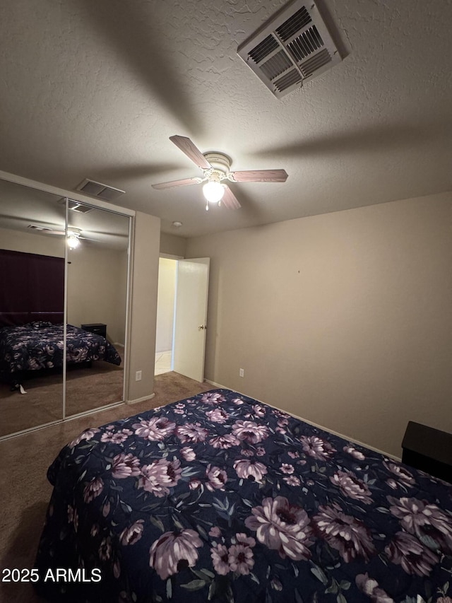 unfurnished bedroom featuring a textured ceiling, a closet, carpet, and visible vents