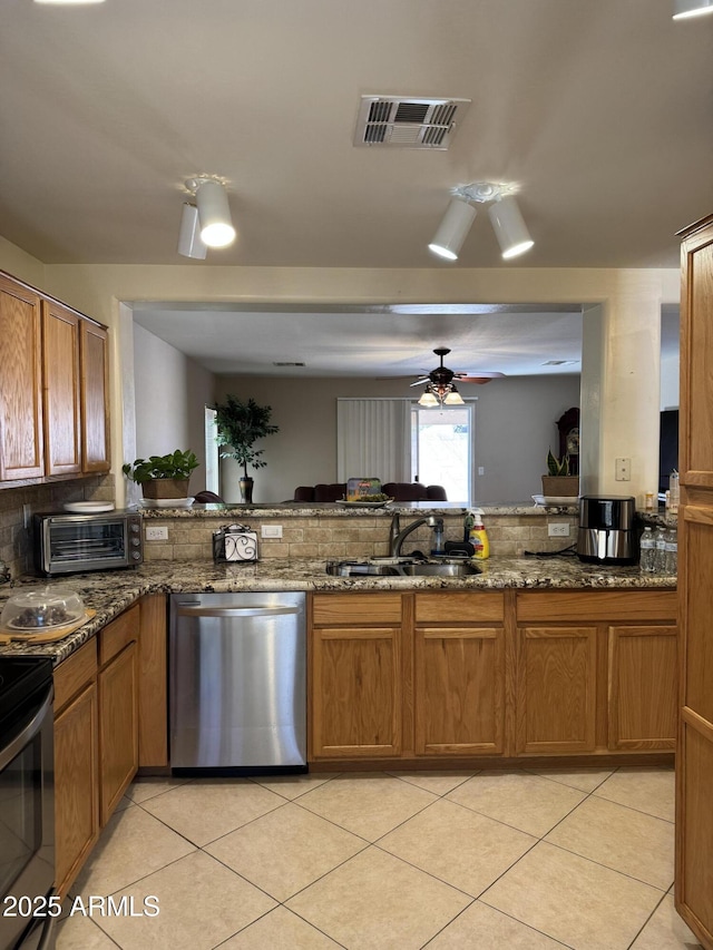 kitchen with a toaster, visible vents, appliances with stainless steel finishes, brown cabinets, and a sink