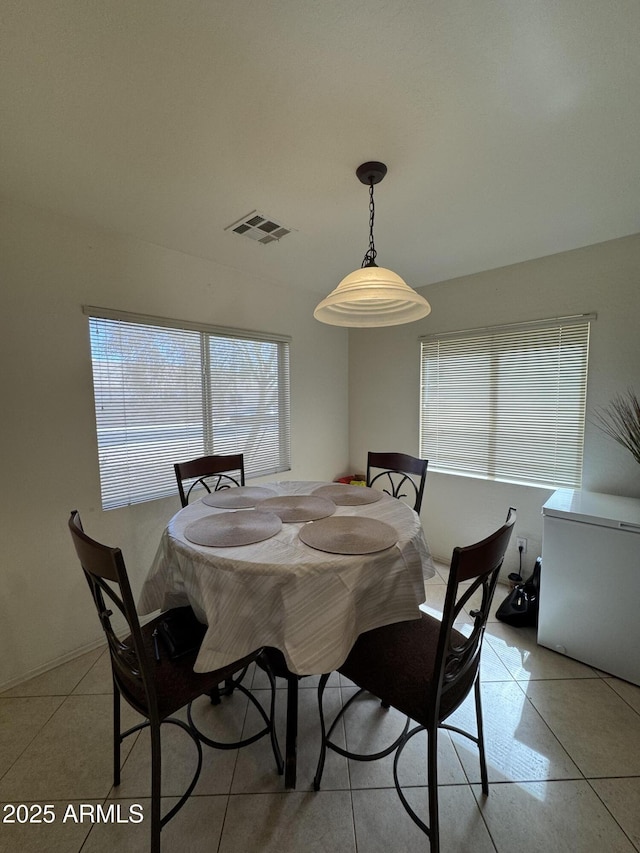 dining space with visible vents and light tile patterned flooring