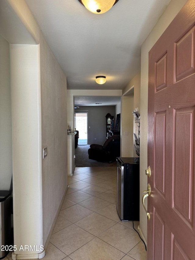 hallway with baseboards and light tile patterned floors