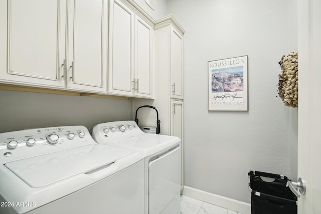 washroom with washer and dryer and cabinets