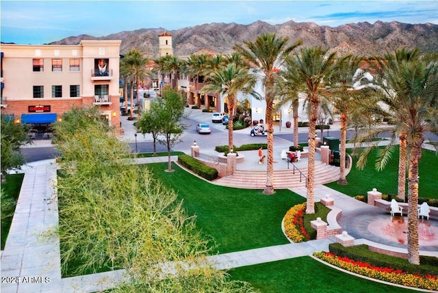 view of community with a mountain view and a yard