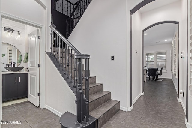 20689 W Valley View Dr, Buckeye, AZ 85396 - stairs featuring arched walkways, tile patterned flooring, and baseboards